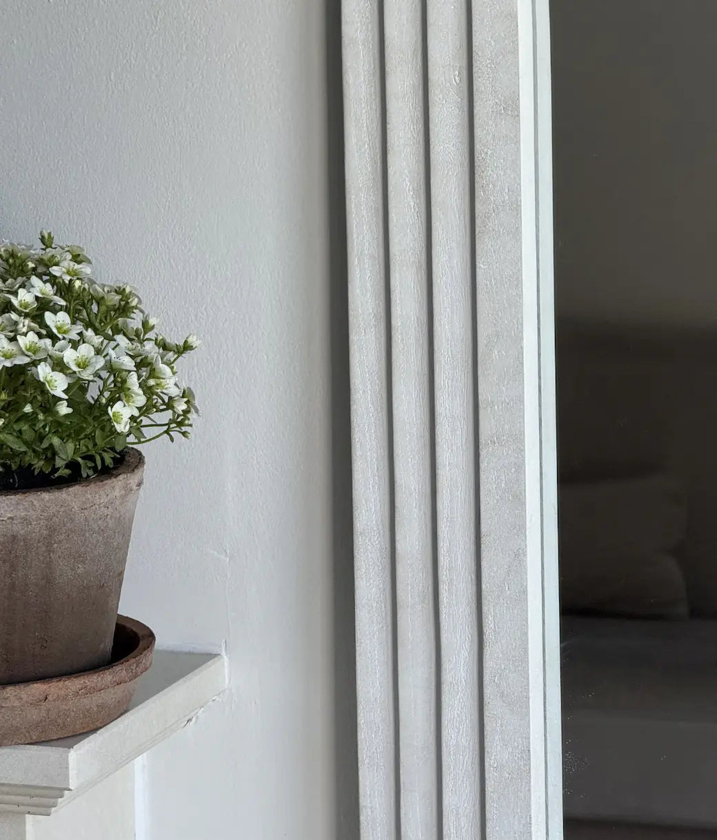 Close up Textured white ribbed frame arched mirror